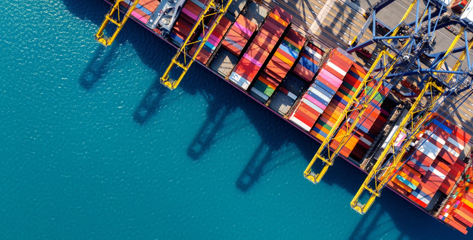 Vista aérea de un puerto de contenedores con buques atracados, punto de llegada de las importaciones desde China a Chile
